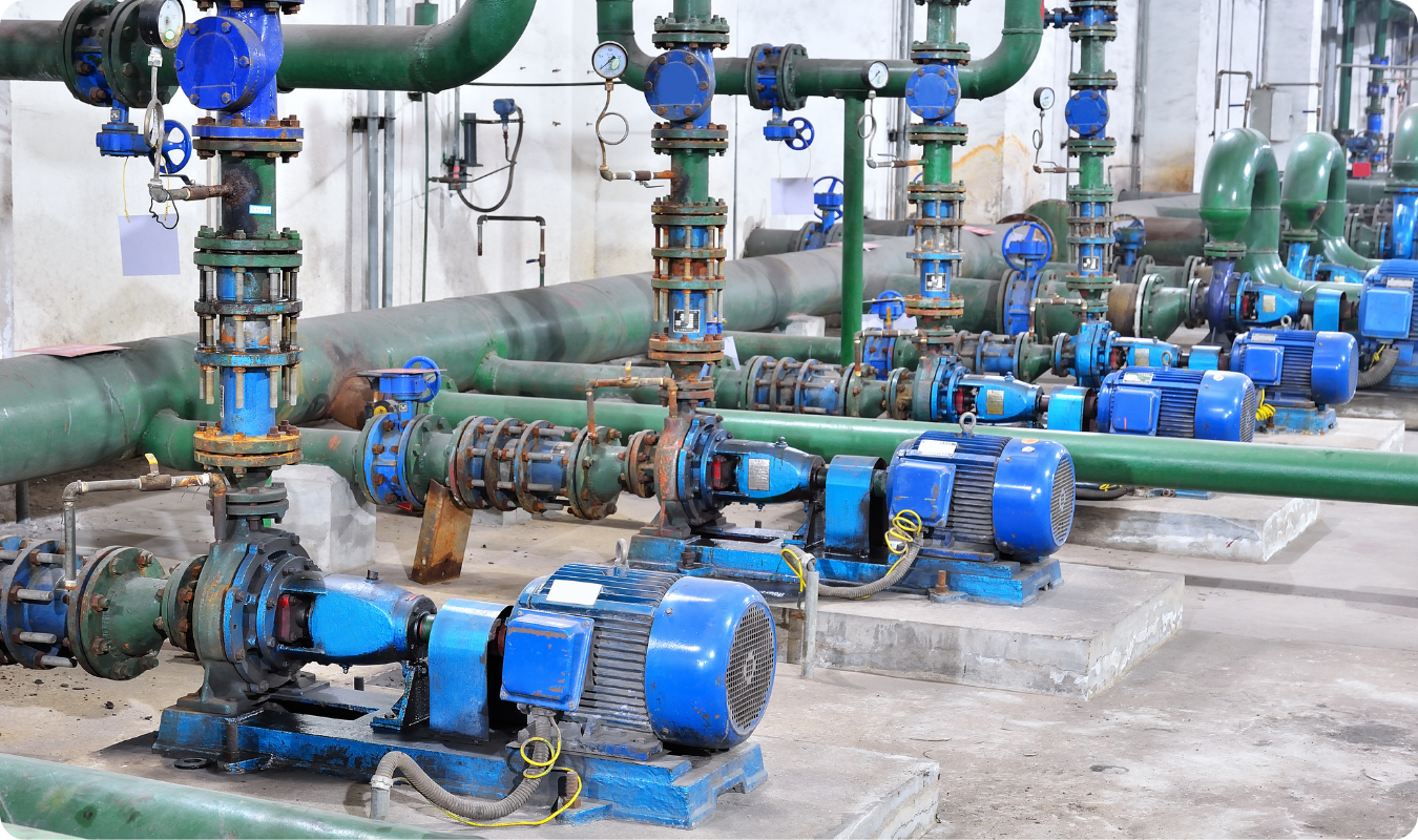 Fileira de bombas centrífugas industriais instaladas em uma estação de tratamento de água, conectadas a tubulações verdes robustas, exemplificando aplicações de grande porte em Manaus.