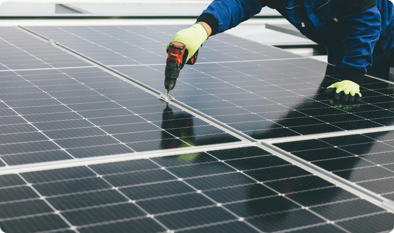 Técnico instalador utilizando parafusadeira elétrica para fixar painéis solares fotovoltaicos, destacando o processo de montagem de um kit de energia solar em Manaus.