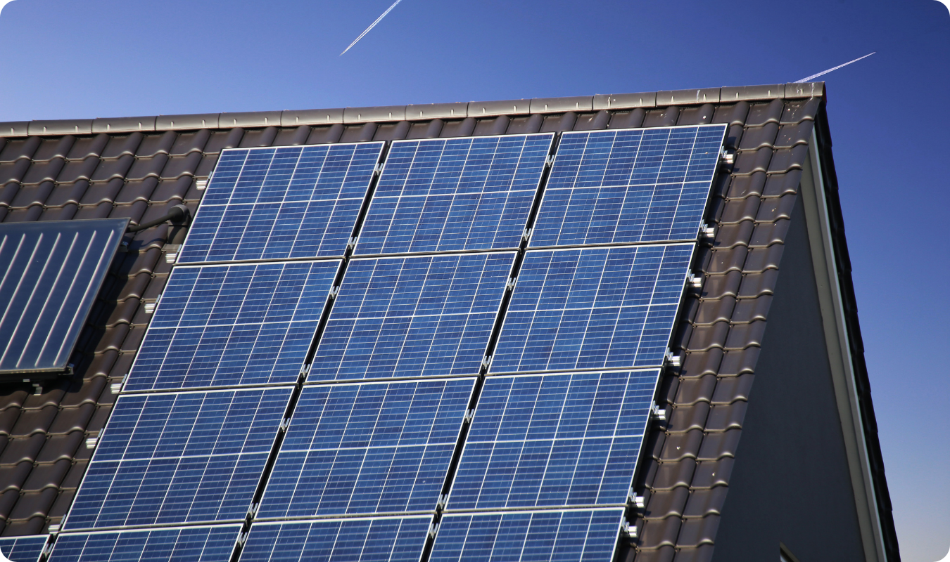 Painéis solares fotovoltaicos instalados em telhado residencial de cerâmica escura, destacando a tecnologia de energia solar em Manaus sob um céu azul limpo.